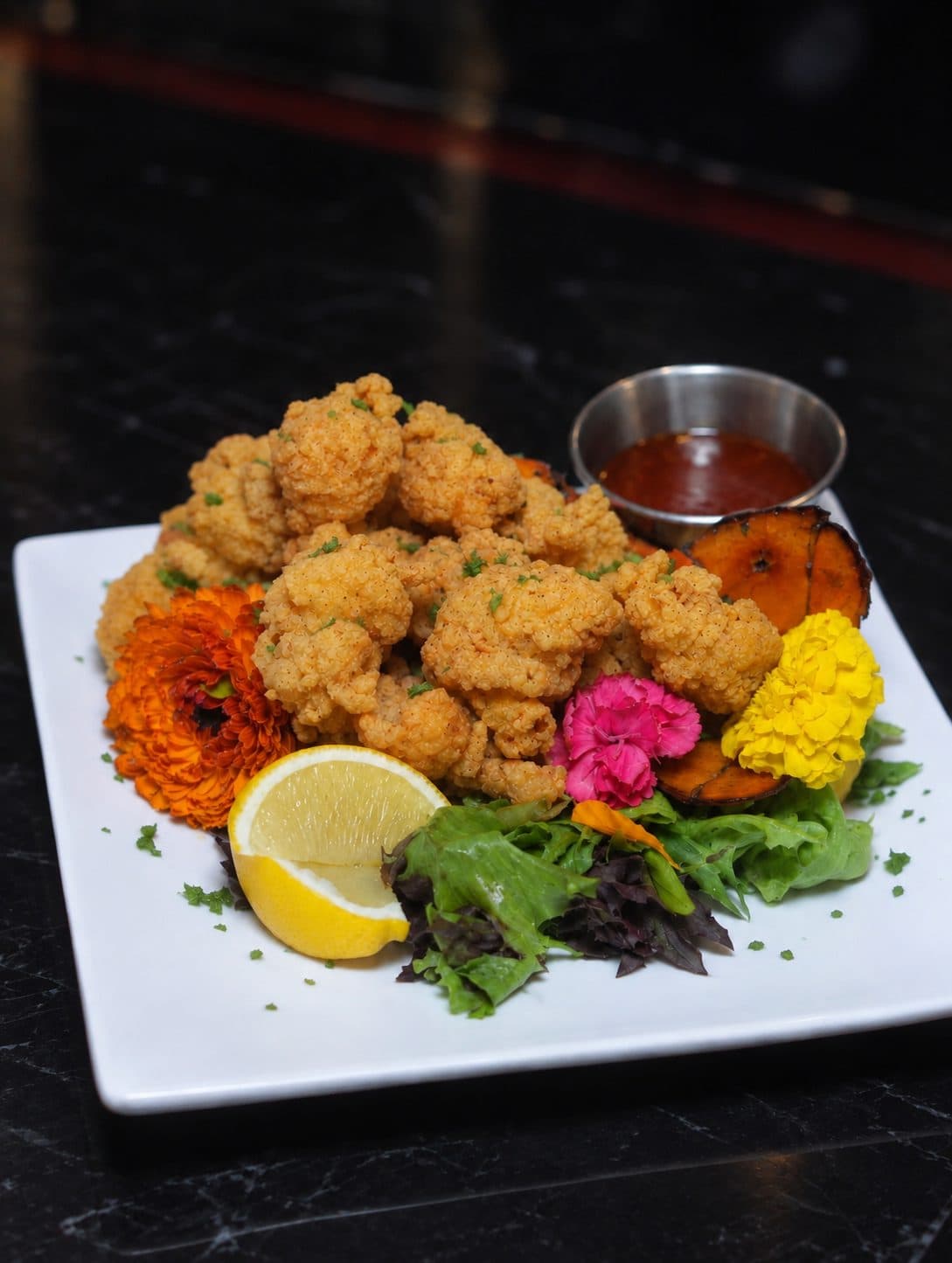 Crispy fried bites with dipping sauce and lemon